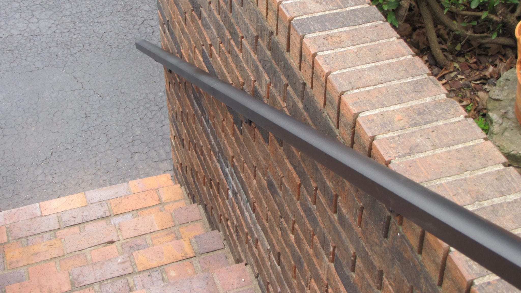 Aluminum Handrail Direct, overhead shot of aluminum handrail on brick wall
