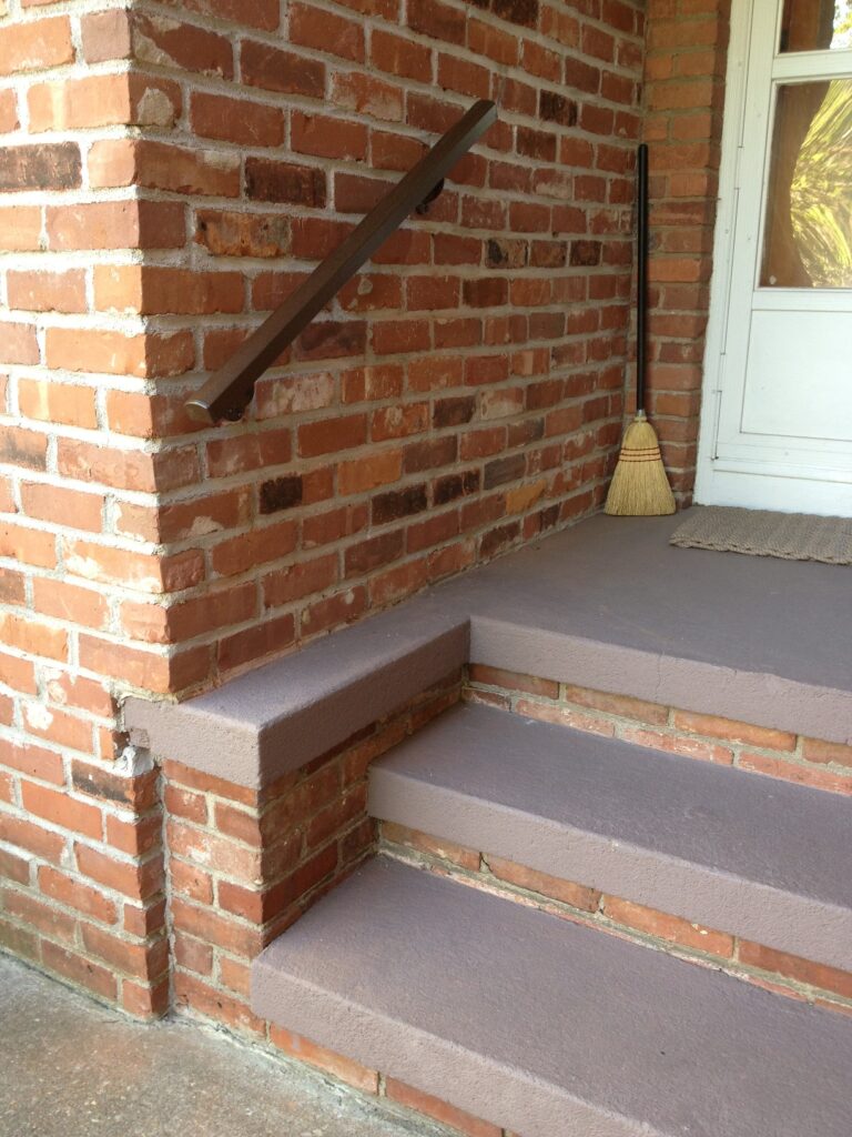 Handrail on concrete steps leading to front door