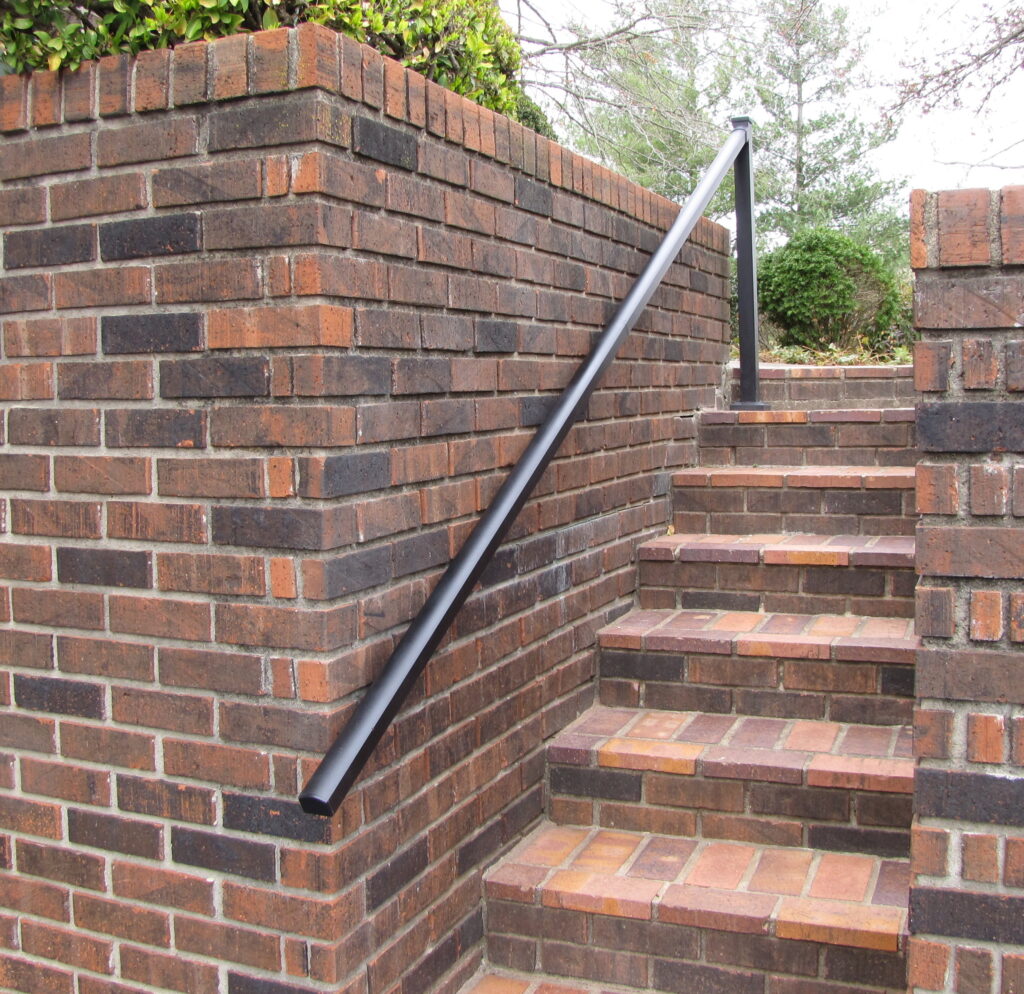 Aluminum handrail on one side of brick stairs