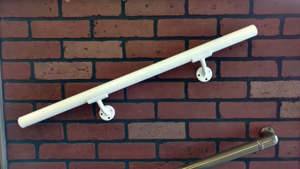 White powder-coated aluminum handrail on brick wall
