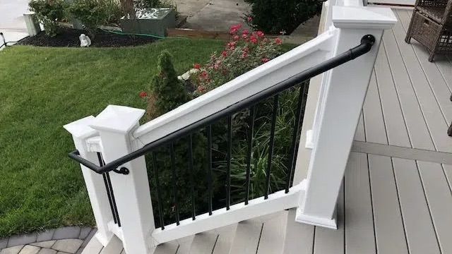 AHD black handrail attached to white railing